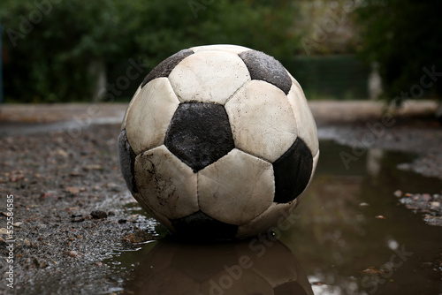 Dirty soccer ball in muddy puddle outdoors © New Africa