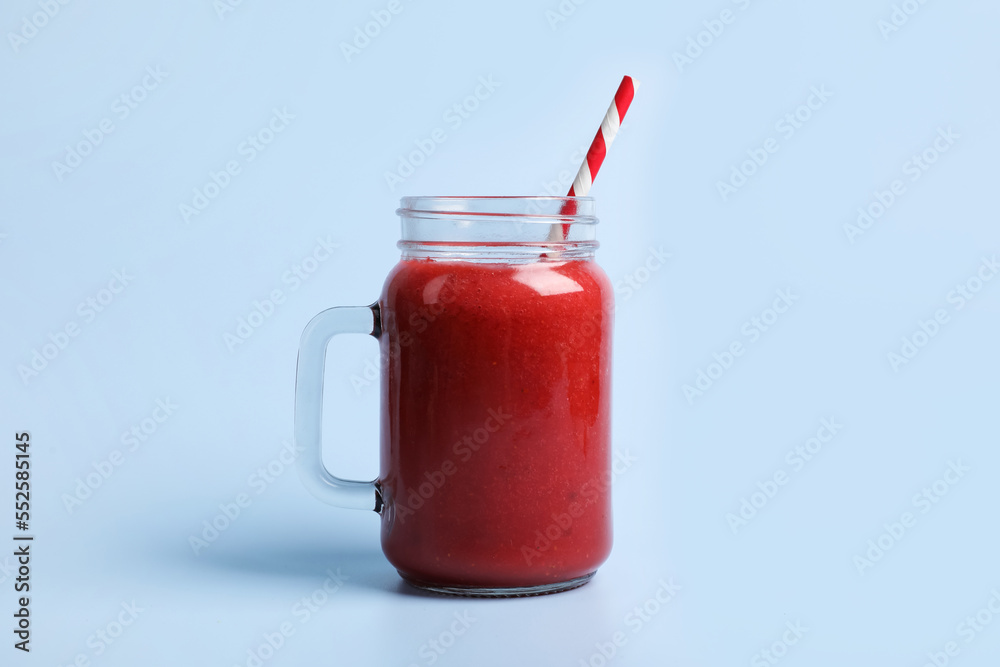 Mason jar with delicious berry smoothie on light blue background Mason jar with delicious berry smoothie on light blue background