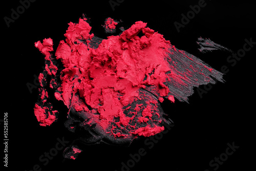Smears of red lipstick on black background, top view