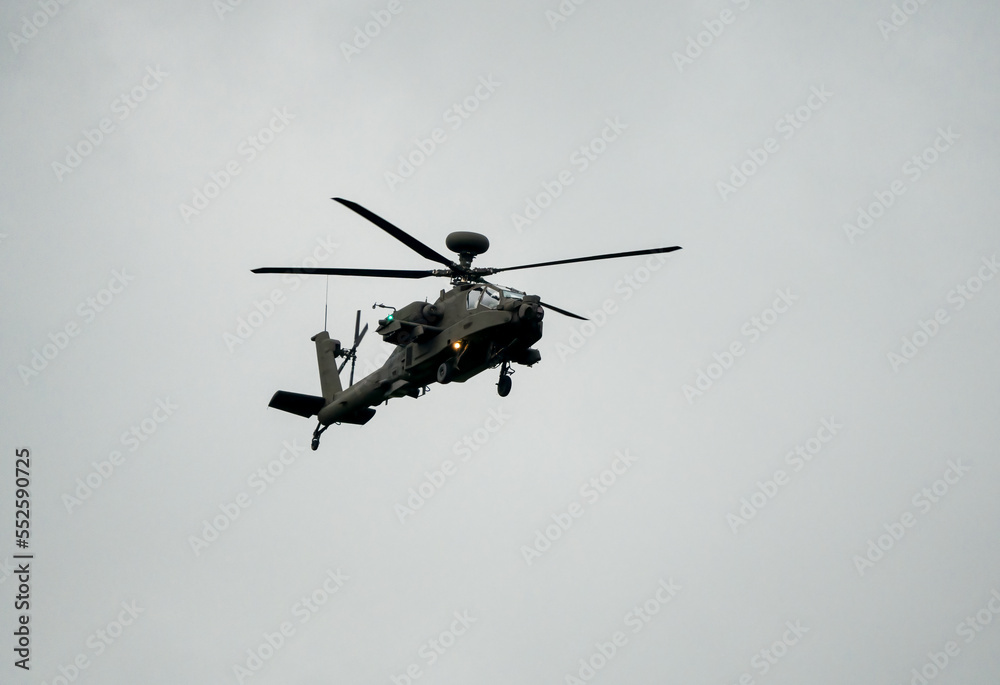 British army AH-64E Boeing Apache Attack helicopter (ZM722 ArmyAir606) on landing approach, autumn sky British army AH-64E Boeing Apache Attack helicopter (ZM722 ArmyAir606) on landing approach, autumn sky