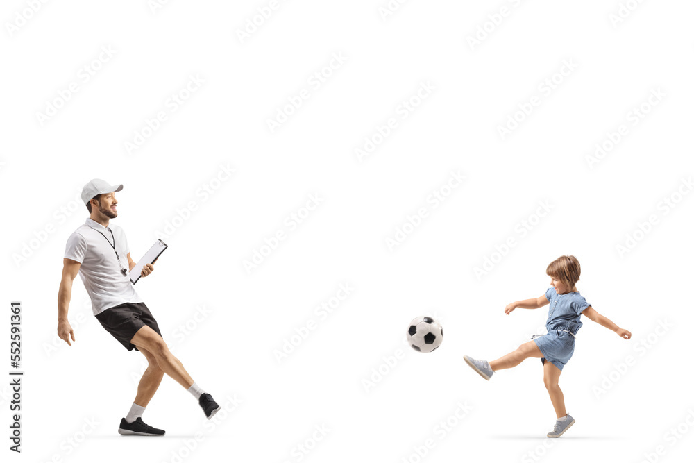 Coach with a whistle holding a clipboard and kicking a ball with a little girl