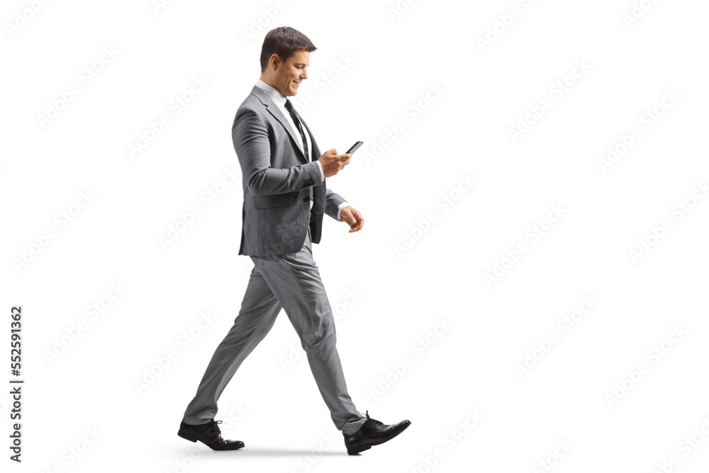 Full length profile shot of a professional man using a smartphone and walking Full length profile shot of a professional man using a smartphone and walking