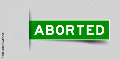 Inserted green color label sticker with word aborted on gray background