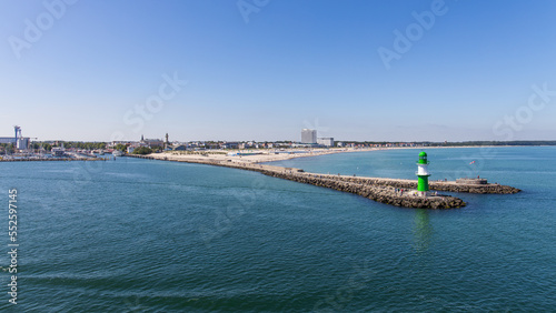 View over the beach area of Warnemünde, Rostock in Germany with a small pier and light tower on a beautiful summer day