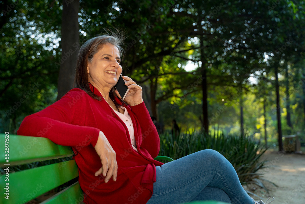 Indian woman talking on smartphone at park Indian woman talking on smartphone at park