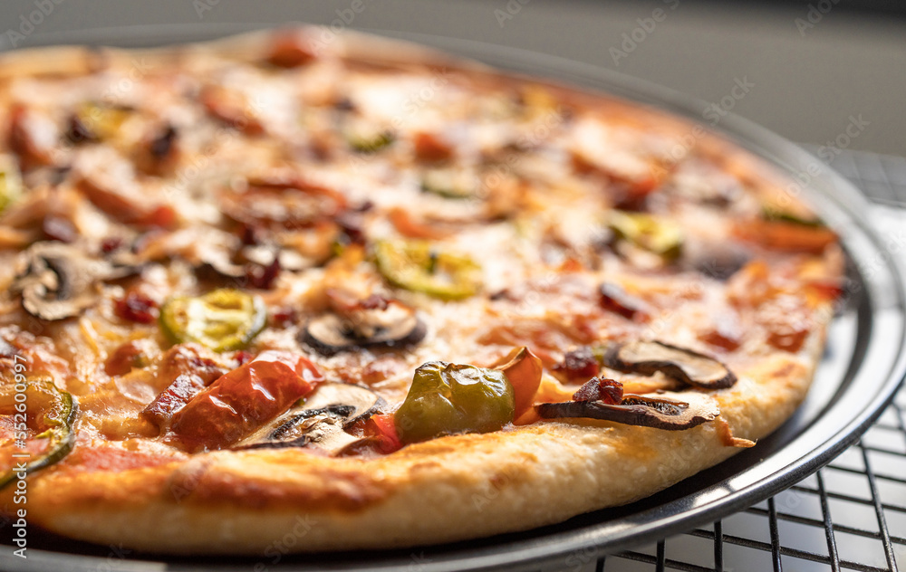 Very close shot of a freshly made green pepper, onion, mushroom, cherry tomato, mozzarella, pepperoni and ham pizza. Copy space. Very close shot of a freshly made green pepper, onion, mushroom, cherry tomato, mozzarella, pepperoni and ham pizza. Copy space.