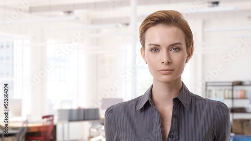 Confident young white businesswoman smiling in modern business office. Portrait of adult woman in 20s, happy confident smile. Copy space. Free Download Confident young white businesswoman smiling in modern business office. Portrait of adult woman in 20s, happy confident smile. Copy space. - GFXLoad