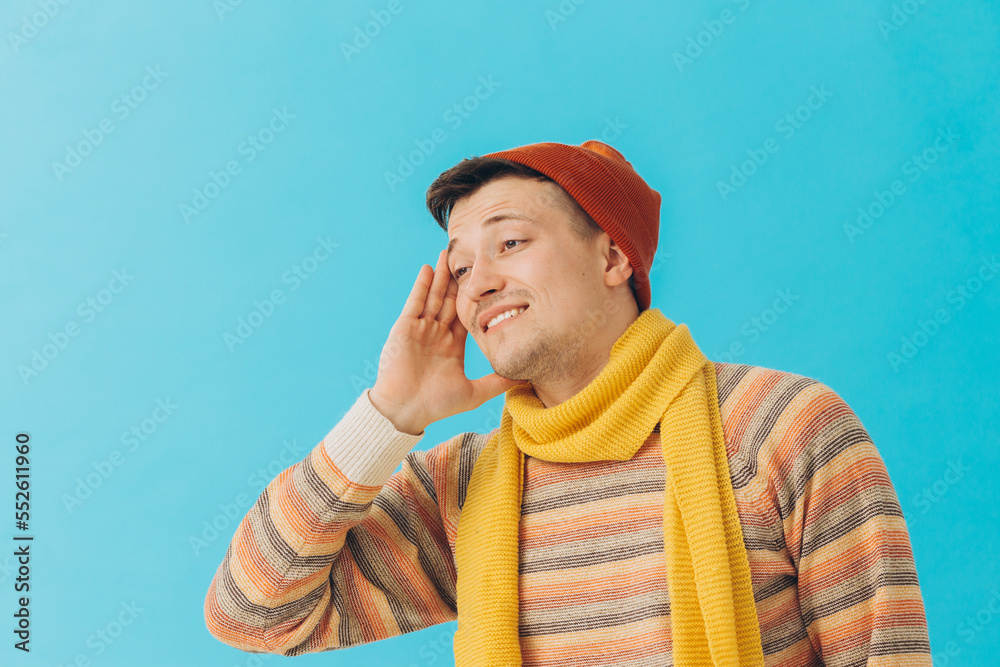 Handsome young man in winter clothes on color background.