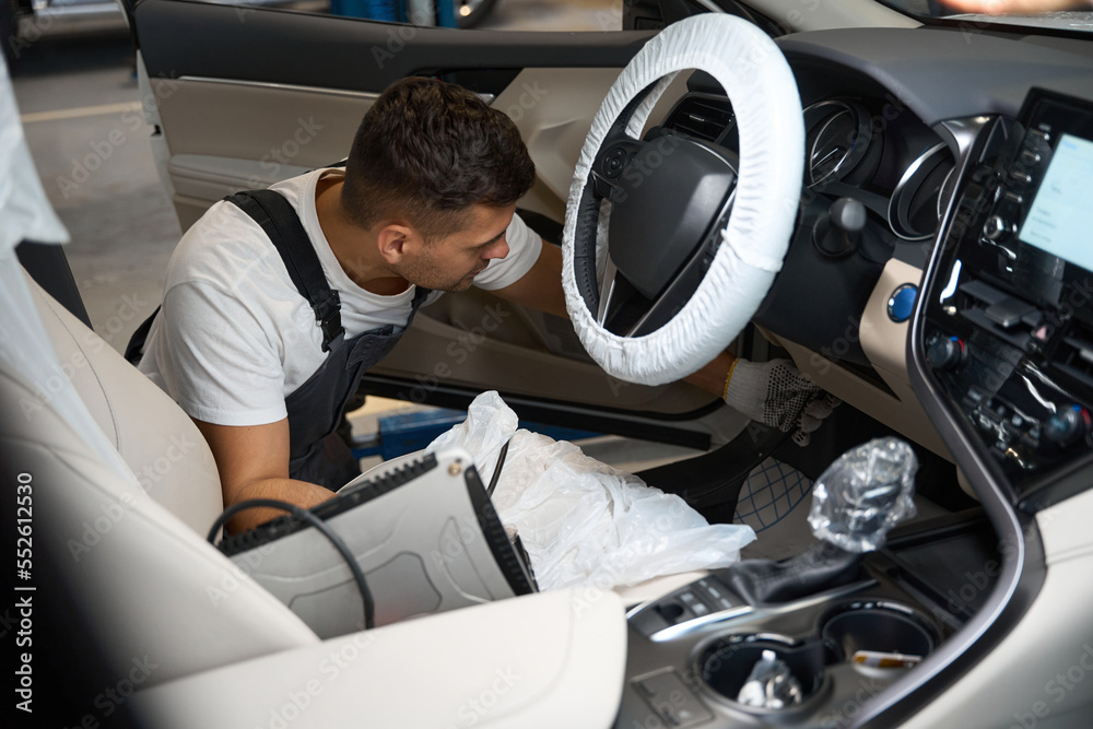 Man checking technical condition of car in the salon Man checking technical condition of car in the salon