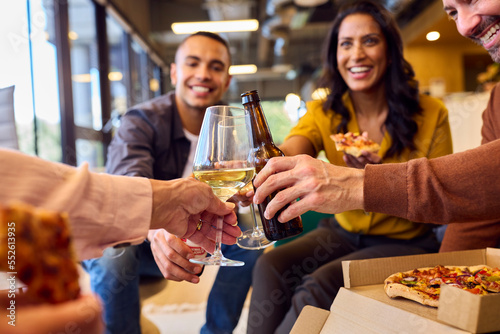 Close Up Of Staff At Informal Meeting In Office With Takeaway Pizza And Drinks