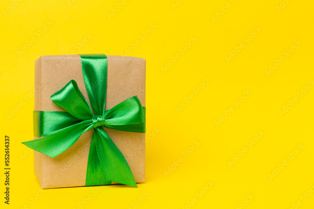 Gift box with green ribbon bow on color background Gift box with green ribbon bow on color background
