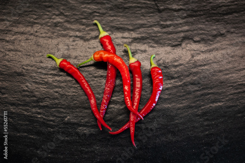 red hot fresh chili peppers on a stylish black kitchen working surface