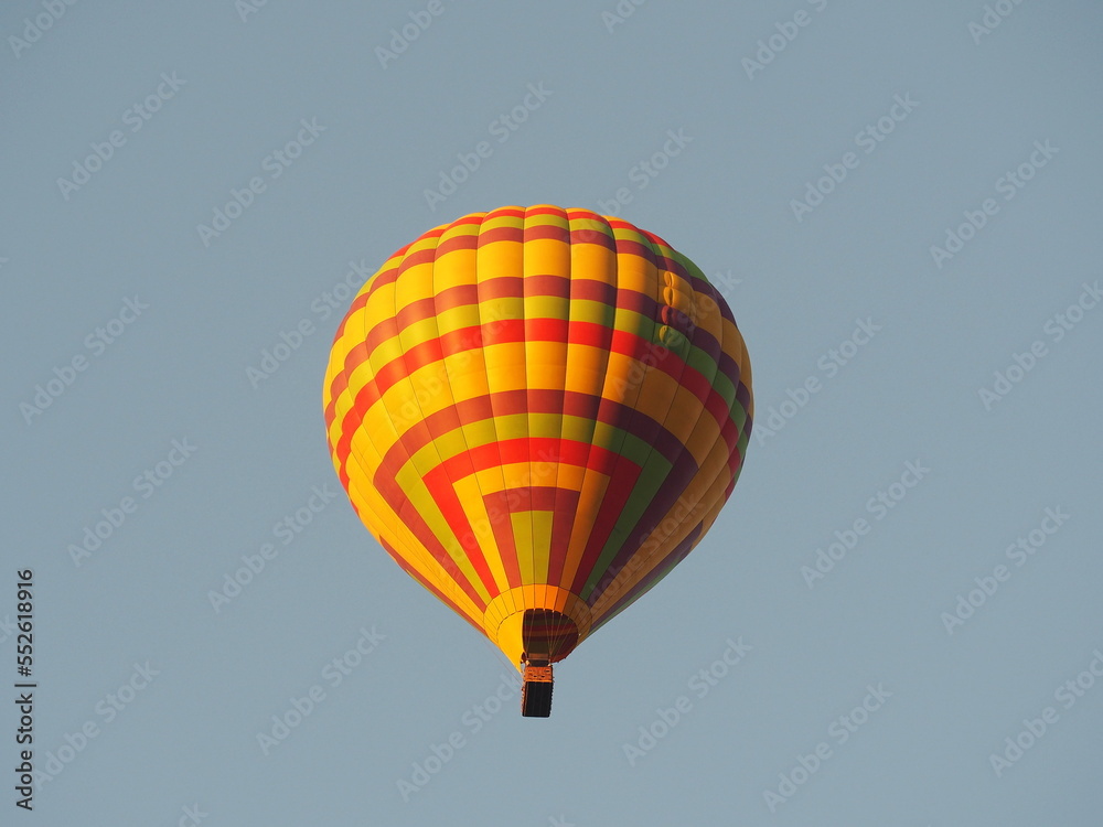 Naklejka premium Hot air balloon over blue sky background. Yellow balloon against the sky in Laos, Vang Vieng 