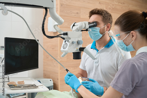 Stomatologist performing dental procedure using modern medical equipment