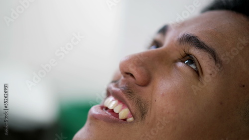 Brazilian man closeup face looking at sky smiling. happy faithful emotion