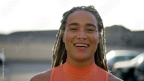 Portrait of a black hispanic latin young woman smiling at camera. Brazilian latin adult girl closeup face © Marco