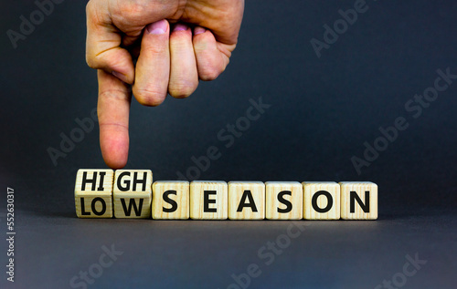 High or low season symbol. Concept words High season and Low season on wooden cubes. Businessman hand. Beautiful grey table grey background. Business high or low season concept. Copy space.