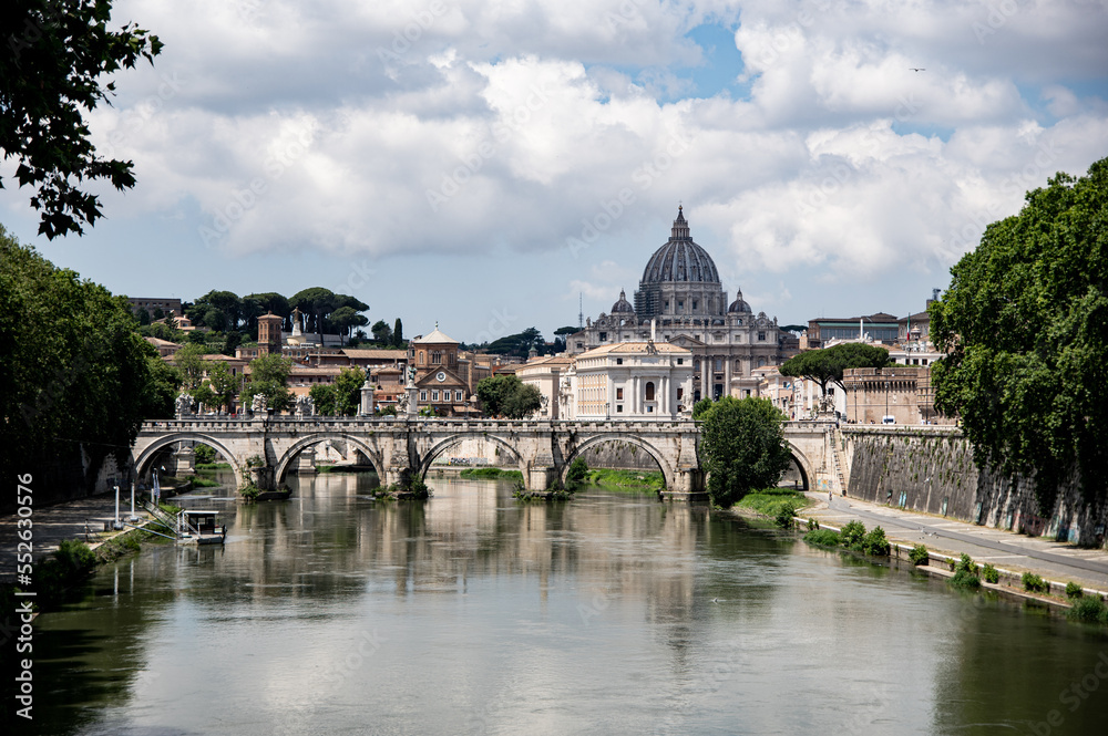 view of Rome from a bridge on the Tevere river with Vatican City on the background
