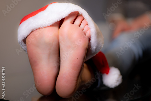 sexy woman feet with a red santa claus hat on. Merry christmas