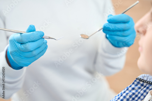 Cropped photo of dentist is receiving a young patient