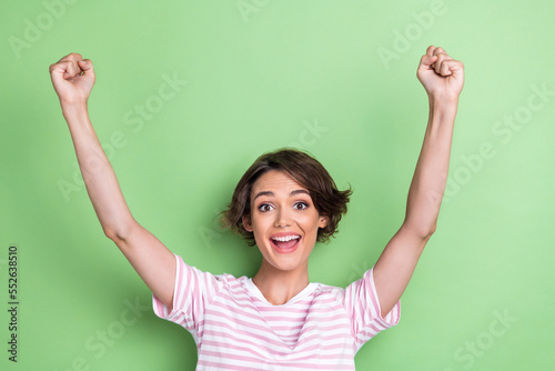 Photo of success millennial lady yell wear white striped t-shirt isolated on green color background © deagreez