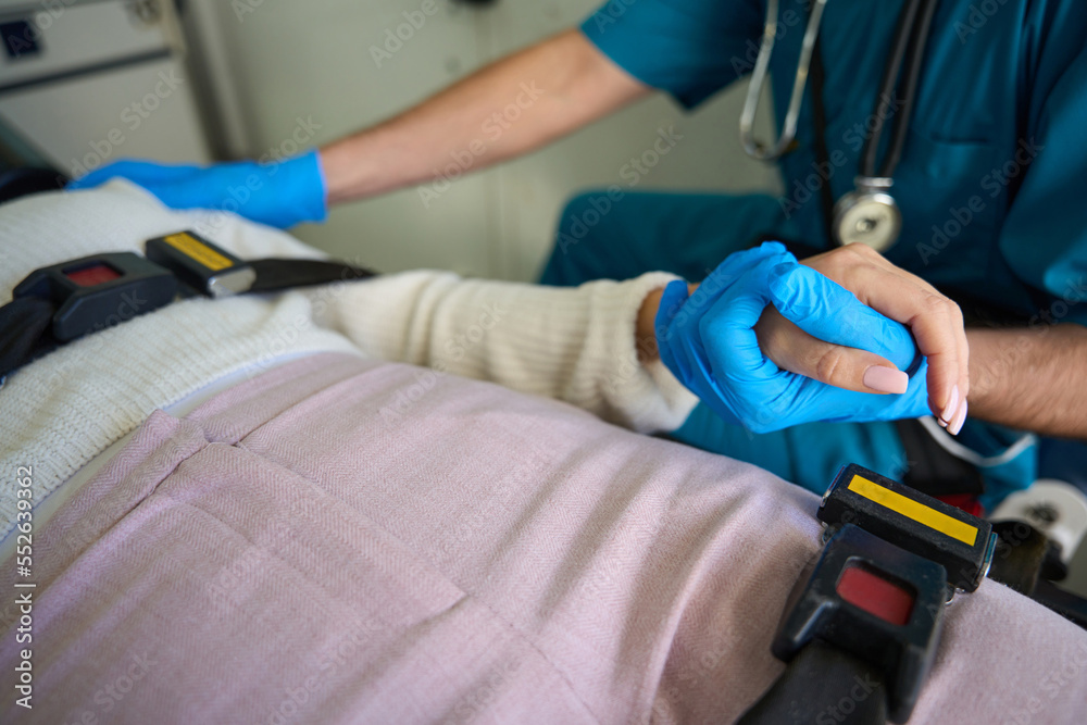 Woman grabs hand of doctor while being transported by ambulance Woman grabs hand of doctor while being transported by ambulance
