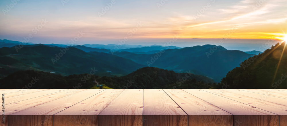 Wooden table top with sunset mountain landscape, for display product.