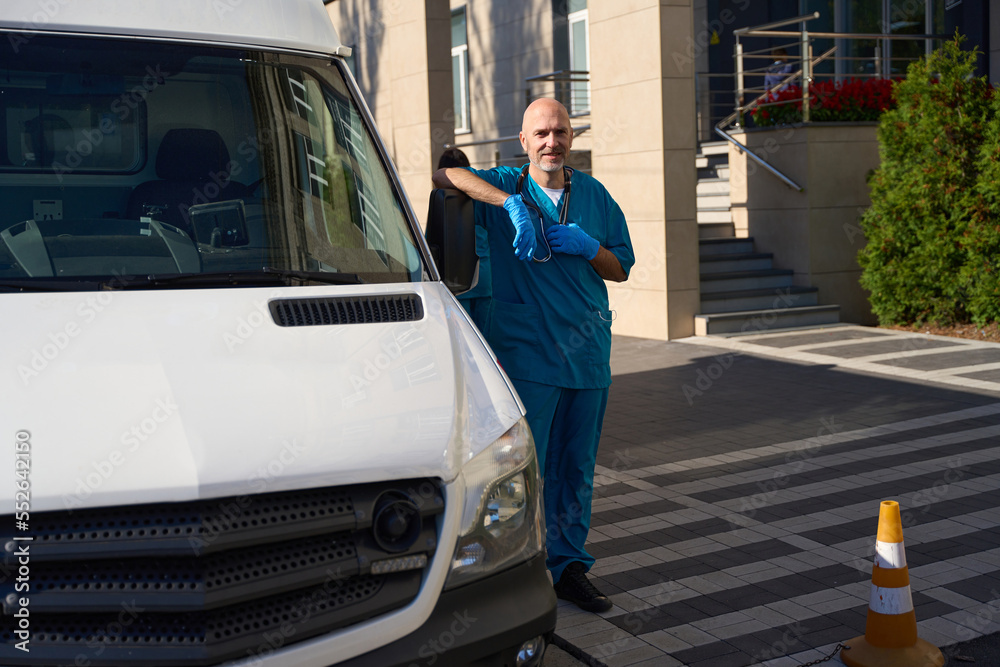 Man in sterile gloves stands near cab of white van