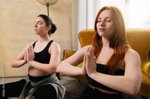 two women practicing relaxing exercises indoor. Preparation for childbirth.