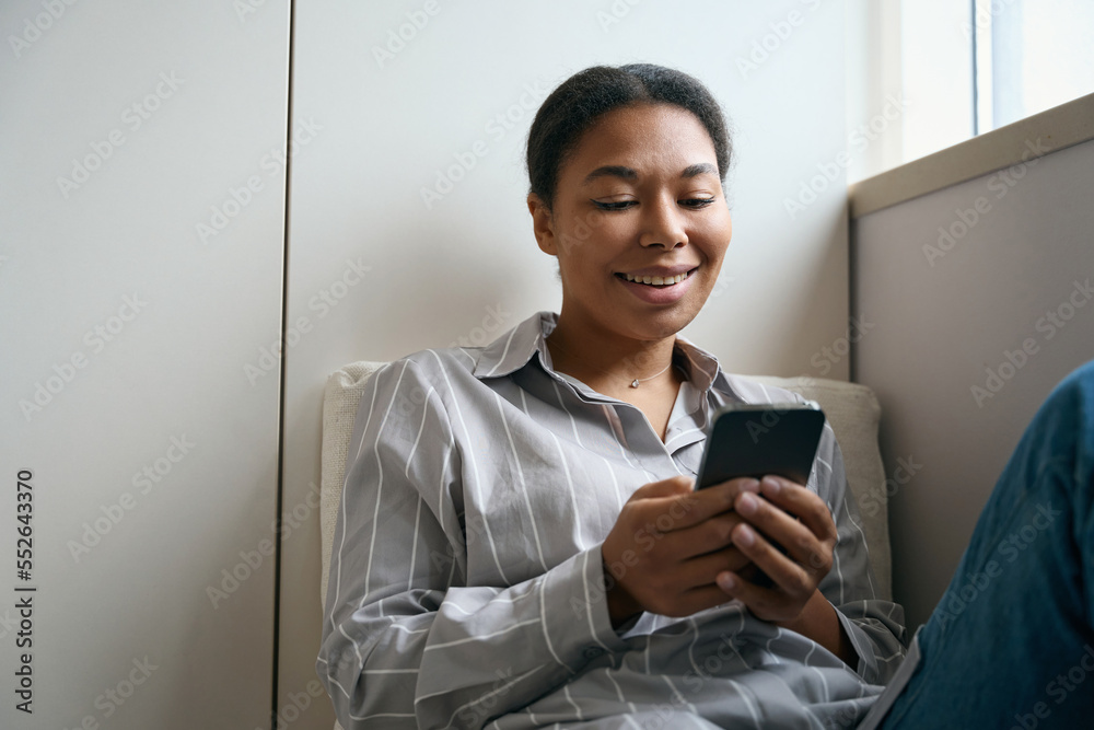 Laughing pretty woman reading message on the screen mobile phone in the room Laughing pretty woman reading message on the screen mobile phone in the room