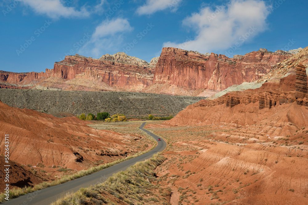 A red car travels the Scenic Drive in Capitol Reef National Park, Utah