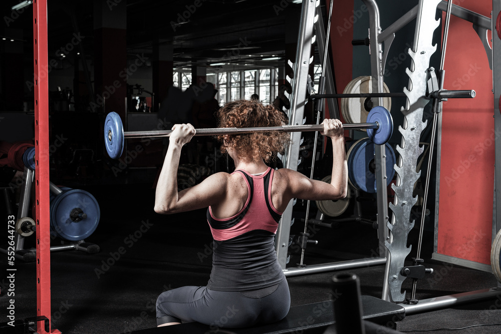 Woman bodybuilder engaged with a barbell in the gym Woman bodybuilder engaged with a barbell in the gym