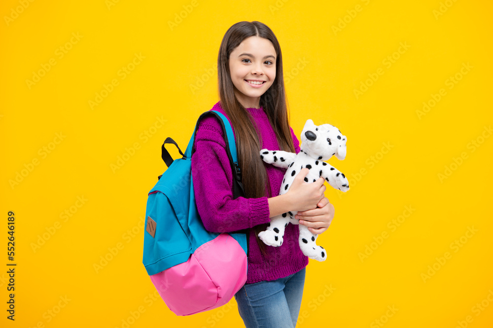 Funny school girl with toy isolated on yellow background. Happy childhood and kids education. Funny school girl with toy isolated on yellow background. Happy childhood and kids education.