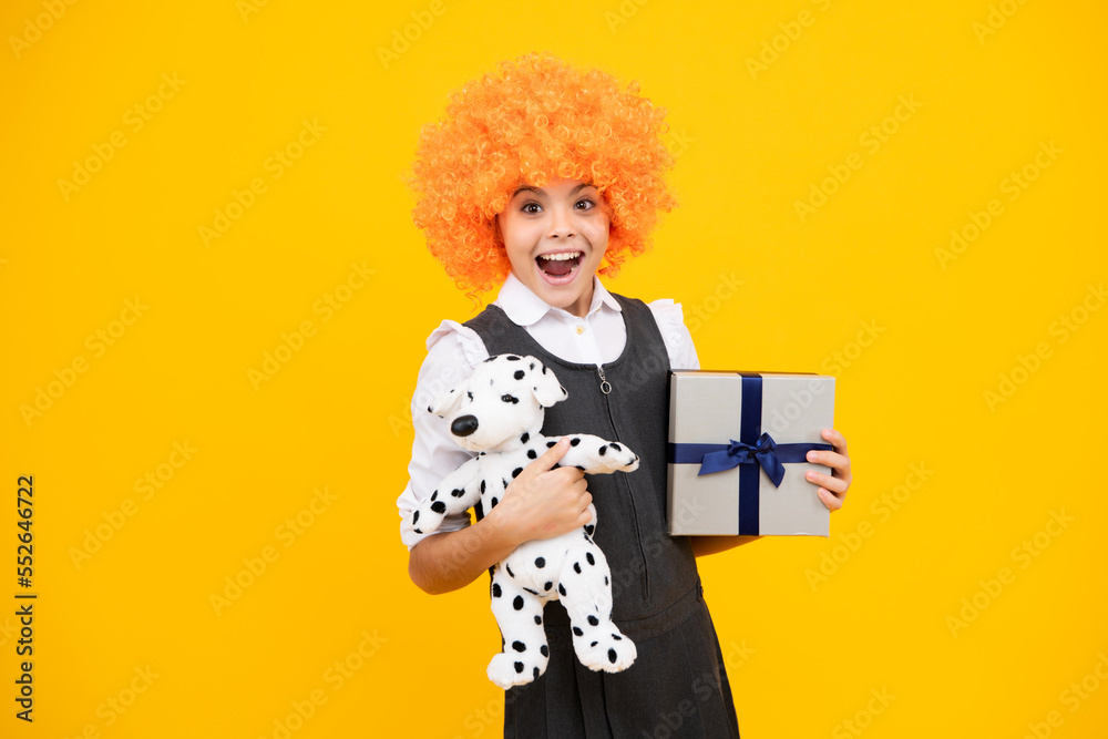 Funny child clown in wig and gift. Presents for birthday, Valentines day, New Year or Christmas. Excited face, cheerful emotions of teenager girl.