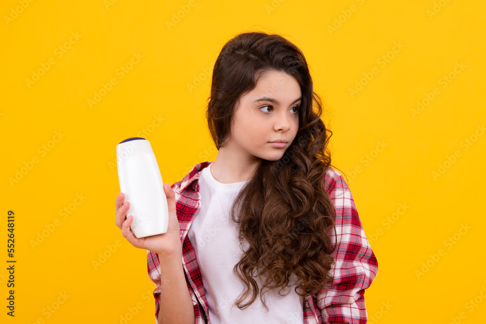 Child teen girl with shampoos conditioners and shower gel. Long hair care of teenager. Presenting cosmetic product, shampoo bottle. Shampooing hair. Child teen girl with shampoos conditioners and shower gel. Long hair care of teenager. Presenting cosmetic product, shampoo bottle. Shampooing hair.