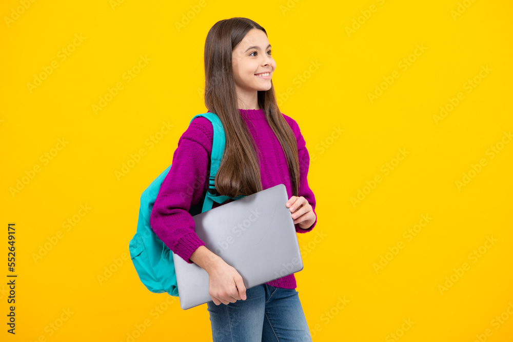 Schoolgirl in school uniform with laptop. Schoolchild, teen student on yellow isolated background. Schoolgirl in school uniform with laptop. Schoolchild, teen student on yellow isolated background.