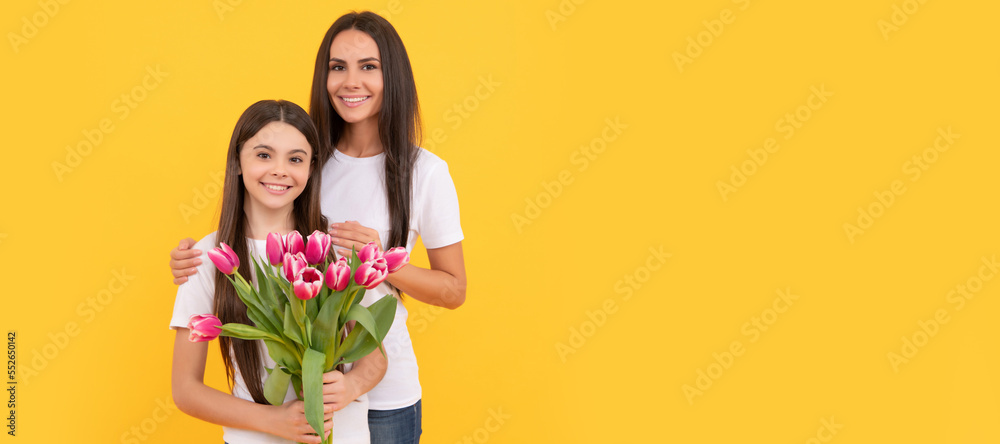 Mother and daughter child banner, copy space, isolated background. happy mother and daughter with fresh tulip flowers on yellow background. Mother and daughter child banner, copy space, isolated background. happy mother and daughter with fresh tulip flowers on yellow background.