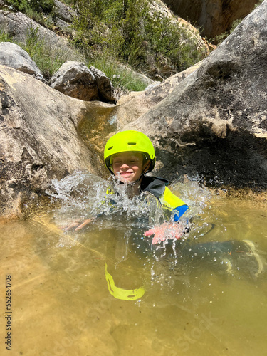 Adrenaline sport - Canyoning. Child with neoprene in mountain ravine
