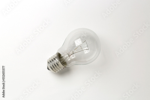 flat lay of single light bulb on white surface