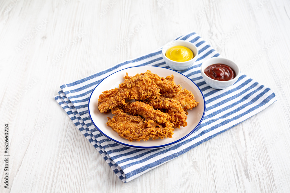 Homemade Chicken Strips with Mustard and BBQ on a Plate, side view. Homemade Chicken Strips with Mustard and BBQ on a Plate, side view.