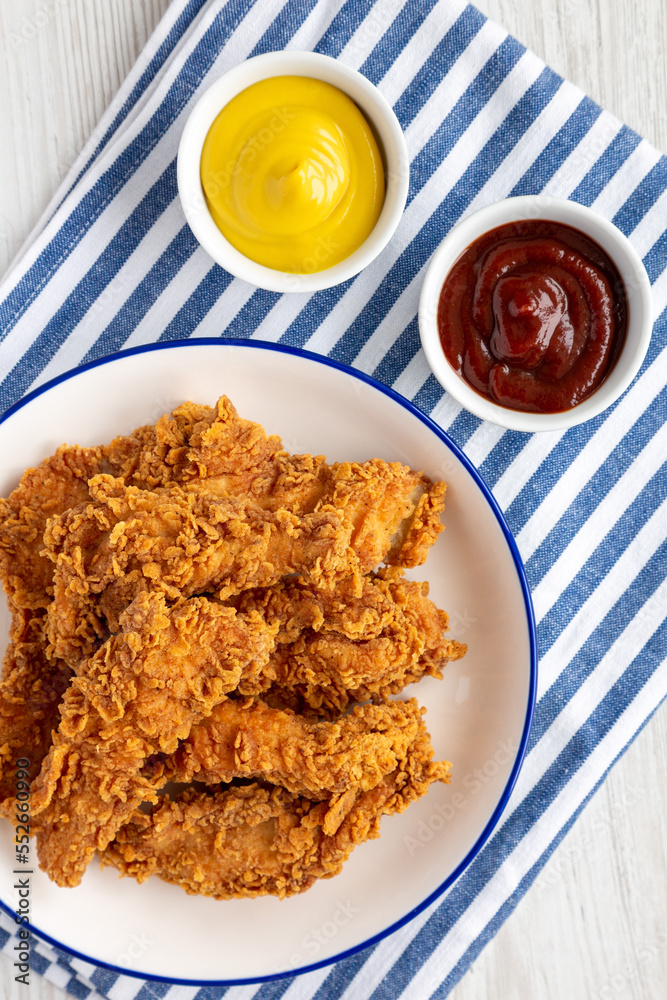 Homemade Chicken Strips with Mustard and BBQ on a Plate, top view. Flat lay, overhead, from above. Homemade Chicken Strips with Mustard and BBQ on a Plate, top view. Flat lay, overhead, from above.