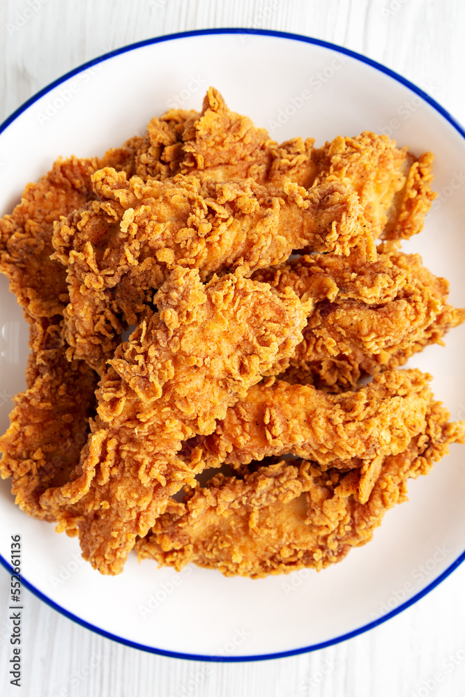 Homemade Chicken Strips with Mustard and BBQ on a Plate, top view. Flat lay, overhead, from above. Close-up. Homemade Chicken Strips with Mustard and BBQ on a Plate, top view. Flat lay, overhead, from above. Close-up.