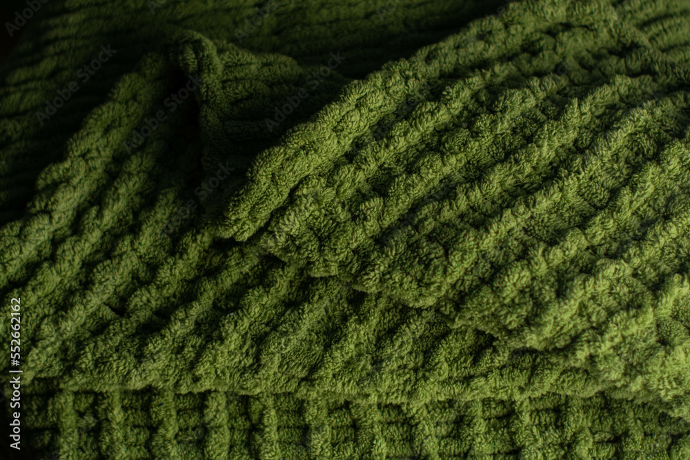 Monochrome background of cozy green knitted sweater