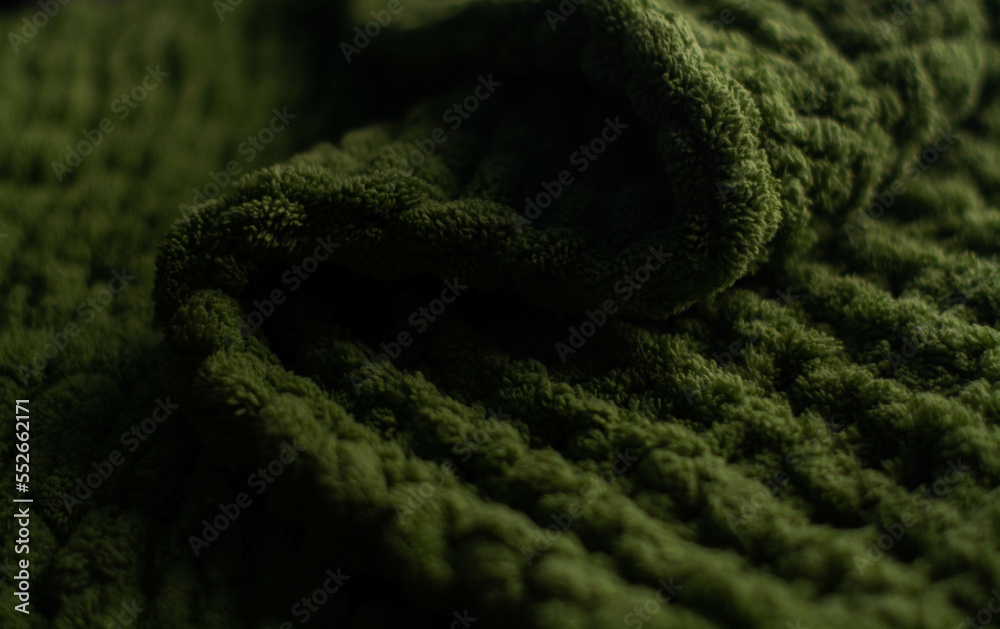 Monochrome background of cozy green knitted sweater