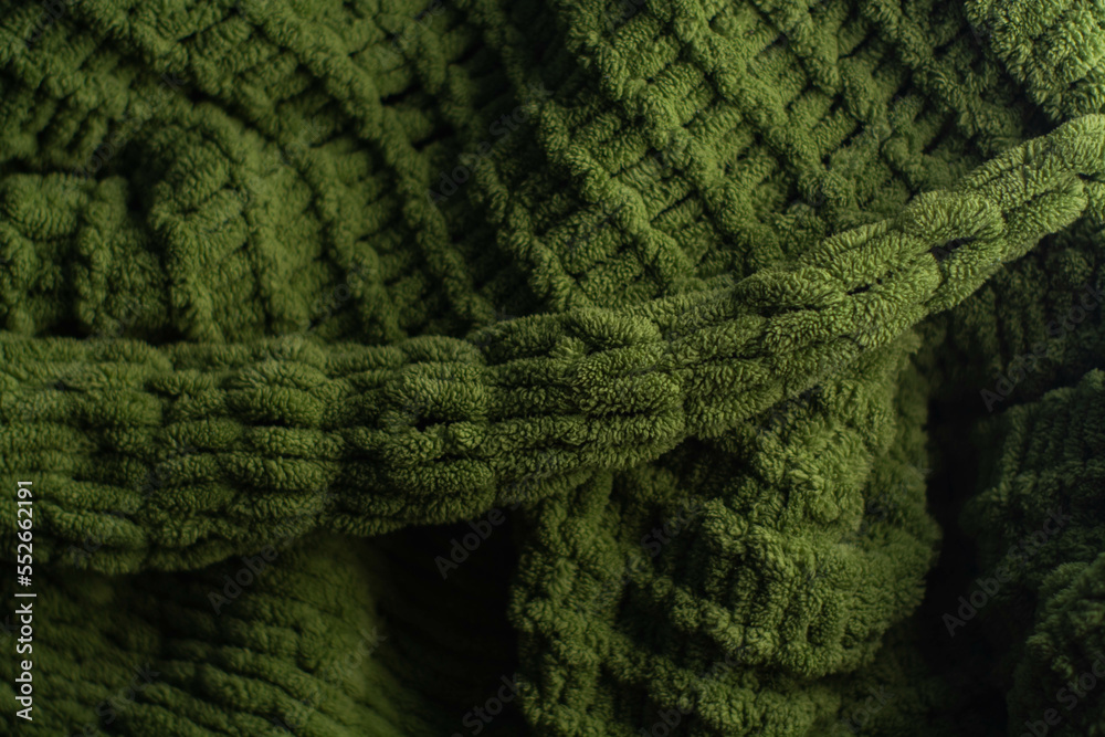 Monochrome background of cozy green knitted sweater