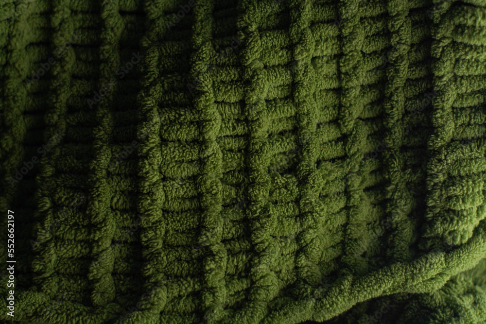 Monochrome background of cozy green knitted sweater