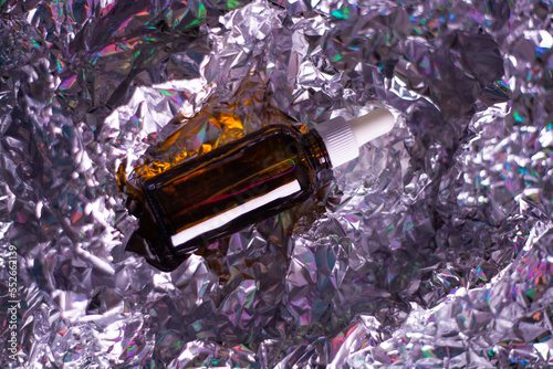 Obraz na płótnie Glass bottle with natural body oil cosmetics on hologram background. w salonie