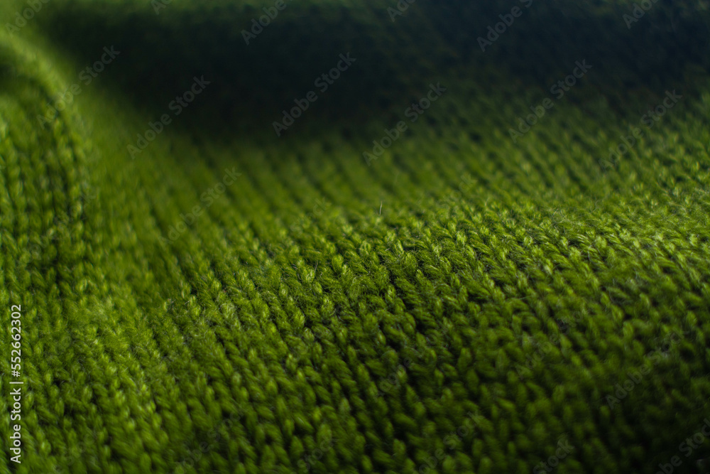 Monochrome background of cozy green knitted sweater