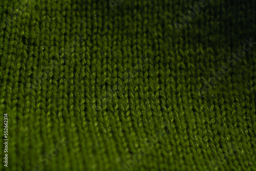 Monochrome background of cozy green knitted sweater