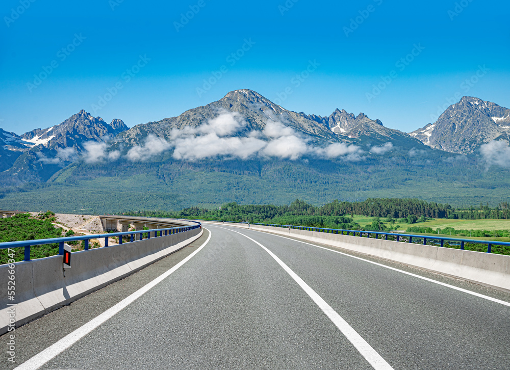 Naklejka premium Asphalt road to mountain on sunset. Traveling concept